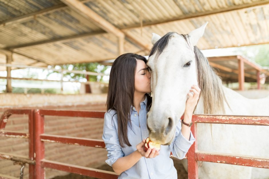 A woman kissing a horse