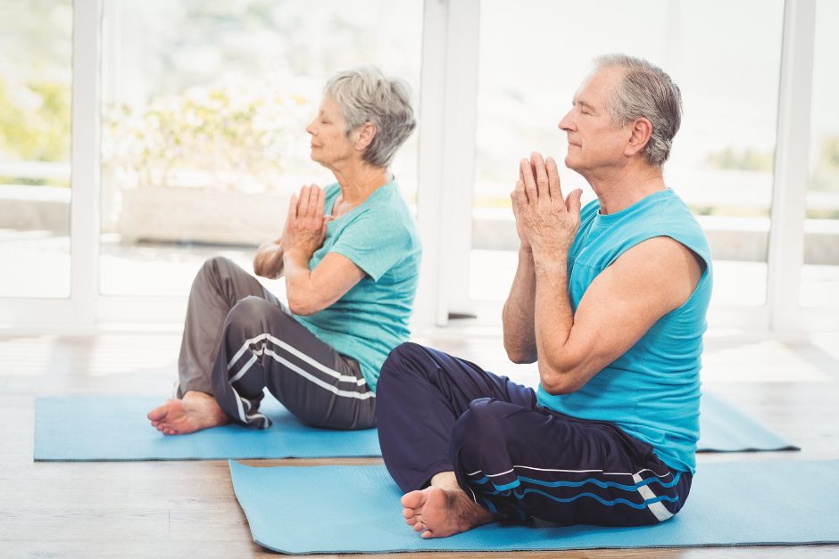 Older man and woman practicing yoga