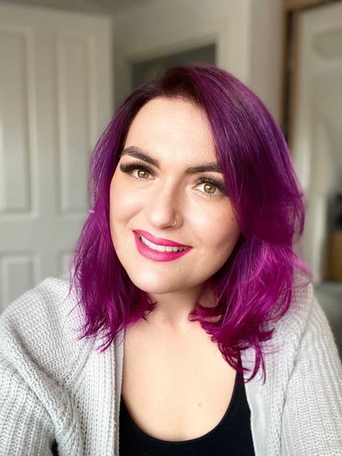 Woman in pink hair smiling