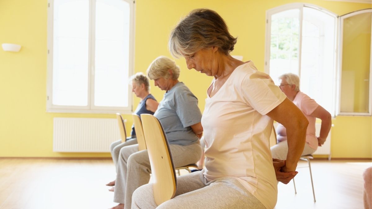 Older group of people doing chair yoga